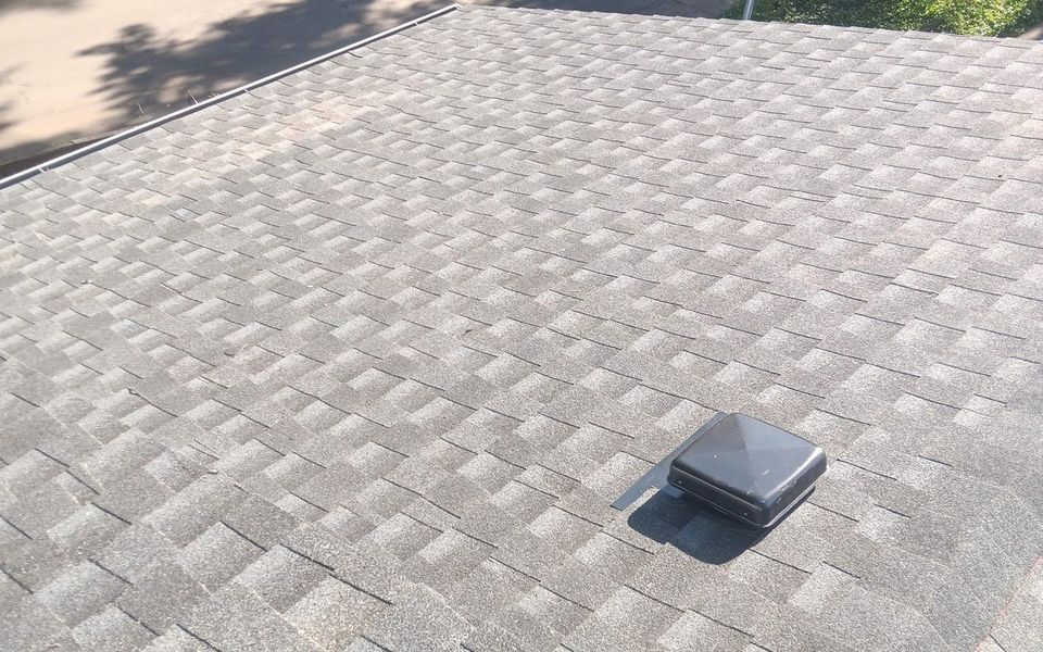 Techo nuevo de tejas grises instalado por Silver Ridge Roofing, visto desde el remate